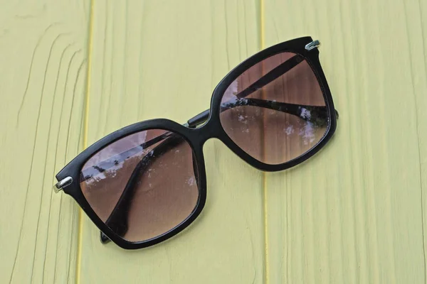 Eine Schwarze Plastiksonnenbrille Mit Braunen Gläsern Liegt Auf Einem Gelben — Stockfoto