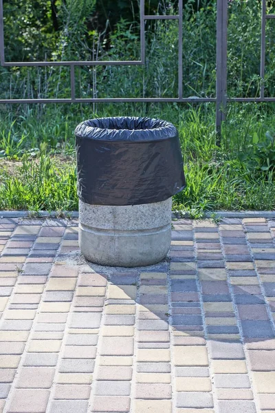 Uma Urna Concreto Cinza Com Saco Preto Fica Uma Calçada — Fotografia de Stock