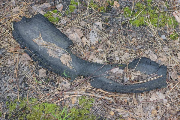 从旧汽车轮胎中取出的一块肮脏的黑色橡胶垃圾躺在街上灰色的地面上 — 图库照片