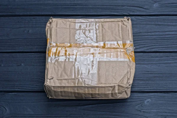 One Brown Paper Closed Square Parcel Cardboard Box Lies Black — Stock Photo, Image