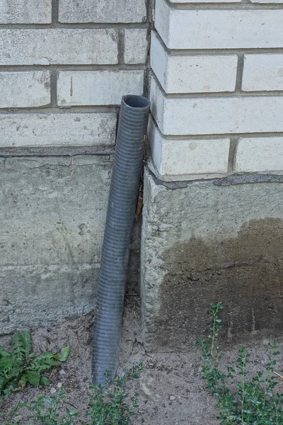 One Black Plastic Hose Pipe Ground Wall Gray Concrete White — Stock Photo, Image