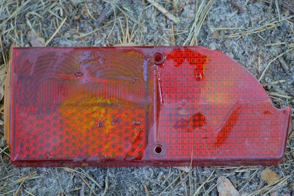 Ein Zerbrochenes Rotes Plastikscheinwerferteil Liegt Auf Dem Grauen Boden Auf — Stockfoto