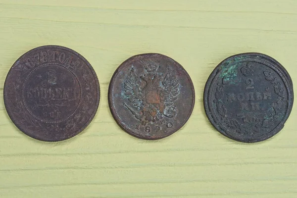 Τρία Παλιά Καφέ Χάλκινα Νομίσματα Βρίσκονται Ένα Κίτρινο Ξύλινο Τραπέζι — Φωτογραφία Αρχείου