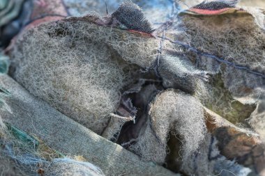 Eski bir ceketin gri yırtık kumaş ve köpük kauçuk astarının dokusu