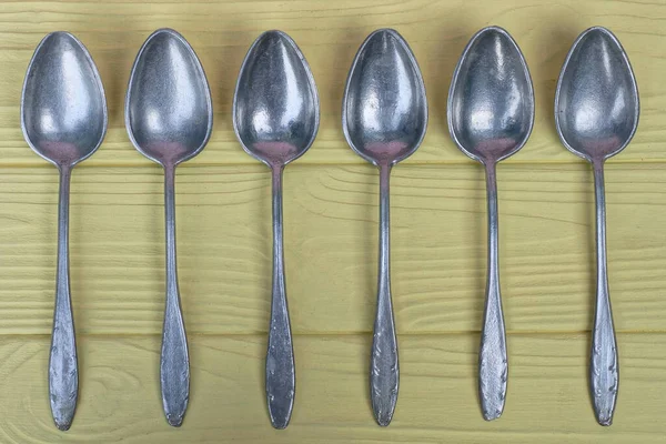 Set Row Six Old Gray Aluminum Spoons Lie Yellow Wooden — Stock Photo, Image