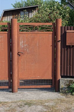 Kırsal kesimdeki bir duvarda kapalı kahverengi metal bir kapı.