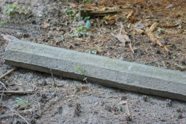 Sokağın gri zemininde eski bir beton direğin büyük bir parçası yatıyor.