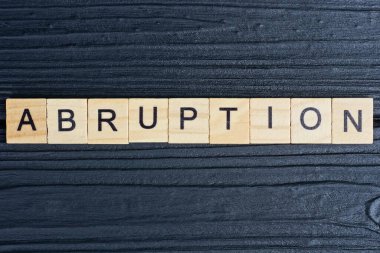 Siyah bir masanın üzerindeki kahverengi ahşap harflerden ayrılma sözcüğünü mesaj at.