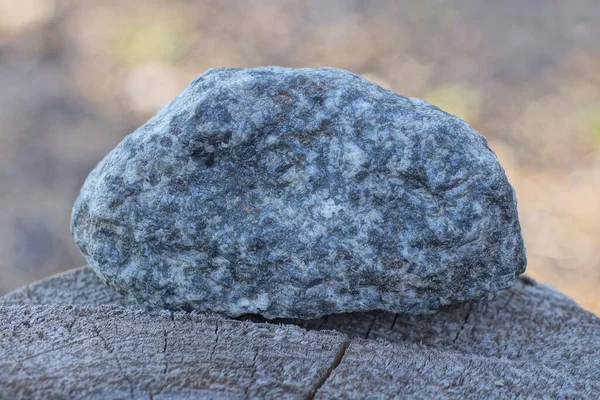 Gri granit bir taş parçası sokakta bir masanın üzerinde yatıyor.