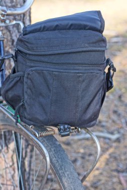Siyah bir bavul, sokakta eski bir bisikletin metal bagajında duruyordu.