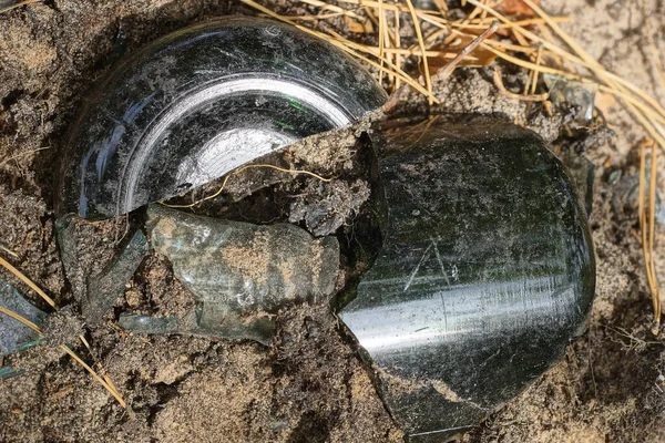 stock image two piece of green brown piece from the bottom of a broken bottle lies on the gray ground in the street