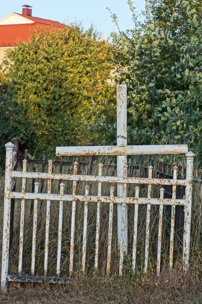 Egy Fehér Fém Kereszt Egy Síron Egy Vas Díszítő Kerítés Stock Kép