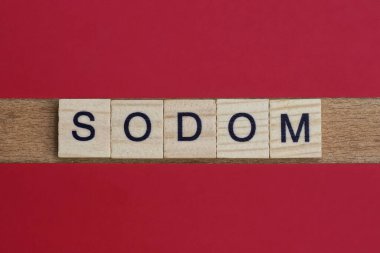 Sodom sözcüğünü kırmızı bir masanın üzerinde siyah yazı tipi olan küçük harflerle yaz.