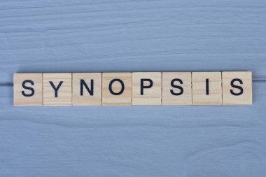 Gri bir masanın üzerinde siyah yazı tipi olan kahverengi ahşap harflerden özet yaz