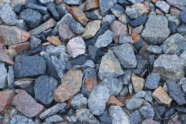 Küçük taşların gri kahverengi dokusu ve sokakta ezilmiş taşlar.