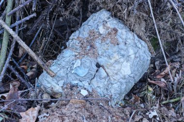 Bir gri kare beton parçası sokakta yerde yatıyor.