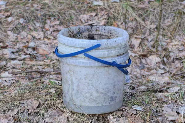 Beyaz kirli plastik kovalar sokakta duruyor.
