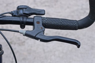 El freni ve sokakta plastik sapı olan siyah metal bisiklet gidonunun parçası.