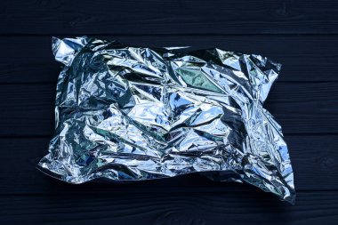 bir kapalı gri plastik torba ambalajı siyah bir masanın üzerinde yatıyor.