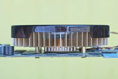 Sarı arka planda elektronik bir video kartında kahverengi bir fan var.