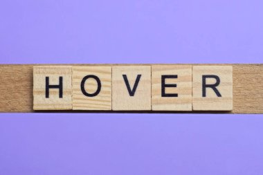 Tahta gri harflerden yapılmış kelime havada asılı eflatun arkaplanda yatıyor