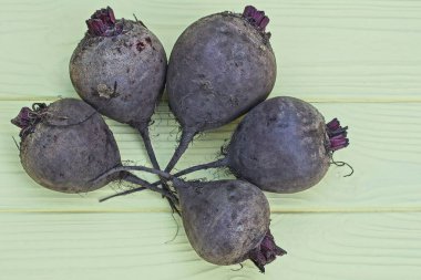 Beş gri, çiğ pancar sarı bir tahta masada yatıyor.