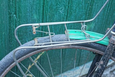 Eski bir bisikletin parçası. Gri demir bir sandıktan. Sokakta bir tekerleğin üstünden.