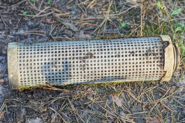 stock image one old white dirty plastic water filter lies on the gray ground on a summer street