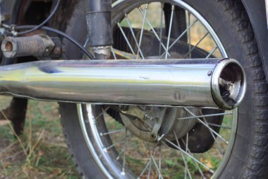 Yaz caddesinde uzun gri metalik egzoz borusu olan büyük bir motosikletin parçası.