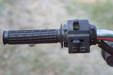 Yazlık sokakta siyah gri direksiyonlu eski bir motosikletin parçası.