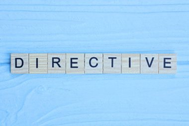 Sözcük direktifi ahşap gri harflerden yapılmıştır mavi arka planda yatar