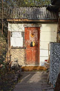 Yazlık caddedeki kırsal evin beyaz duvarında eski bir kapalı kahverengi ahşap kapı.