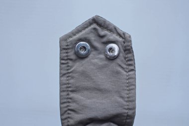 iki metal perçin düğmesi siyah kumaştan bir kemer üzerinde gri bir arka planda bir ceket