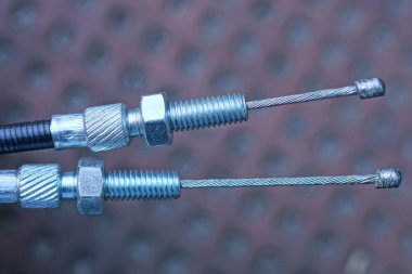 Motosiklet için gri metal fren kablolarının bir kısmı şehir sokaklarında kahverengi arka planda.