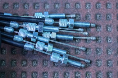 Motosiklet için gri metal fren kablolarının bir kısmı şehir sokaklarında kahverengi arka planda.