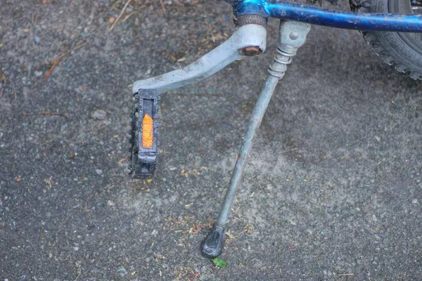 bir pedal ve gri metal kickstand bisiklet üzerinde gri asfalt üzerinde duruyor şehir caddesinde