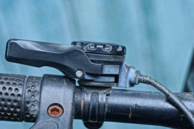 Siyah plastik vitesli bisiklet gidonu parçası ve sokakta kablo.