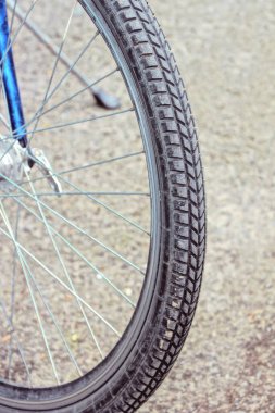 Gri siyah lastik lastikten yapılmış bir tekerleğin parçası ve sokakta bir bisikletin üzerinde metal teller.