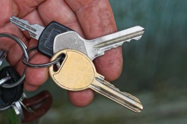 Bir el, sokakta üç tane eski metal kapı anahtarı tutuyor.