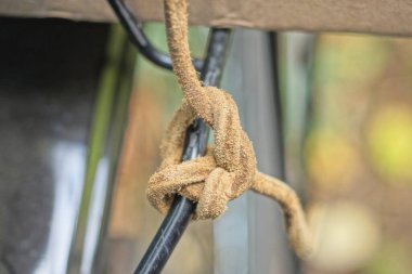 brown rope wound on a blue metal pipe on the street