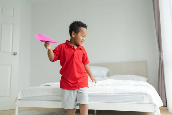 A little boy imagines being a pilot playing with toy planes at home on the floor in his room.