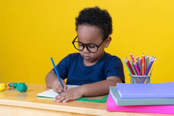 Мальчик Воображением Сидит Столом Рисует Цветными Карандашами Желтом Фоне — стоковое фото