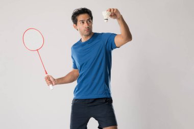 Spor giyim sektöründe bir badminton oyuncusu elinde raket ve beyaz arka planda mekik taşır..