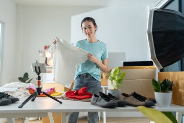 Çevrimiçi mağazada çalışan genç ve güzel bir kadın. Günlük giysiler giyiyor. Müşterinin laptop adresini ve ürün bilgilerini kontrol ediyor..