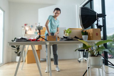 Küçük bir e-ticaret şirketinin genç bir kadın sahibi posta kutusuna eşya koyup bir masada teslim etmeye hazırlanıyor. Bu bir e-ticaret teslimat servisi..