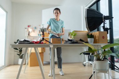 Küçük bir e-ticaret şirketinin genç bir kadın sahibi posta kutusuna eşya koyup bir masada teslim etmeye hazırlanıyor. Bu bir e-ticaret teslimat servisi..