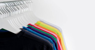 Colorful t-shirts hanging on a rack, background