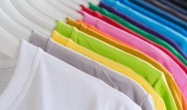 Colorful t-shirts hanging on a rack, background