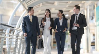 İş adamları modern ofis, liderlik konsepti ve iş başarısı önünde yürür ve birbirleriyle konuşurlar.