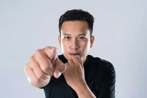 Football referee holding whistle and pointing with isolated hand on white background.